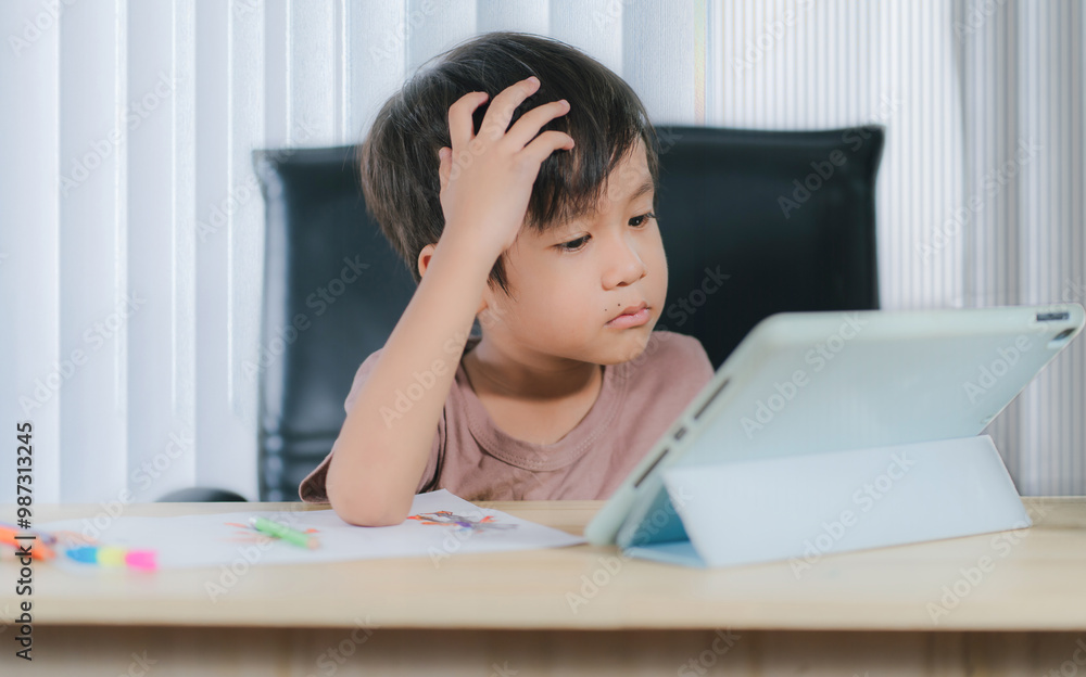 Depressed little boy with tablet,asian child boy learning online on tablet digital at home. Depressed little boy with tablet,asian child boy learning online on tablet digital at home.