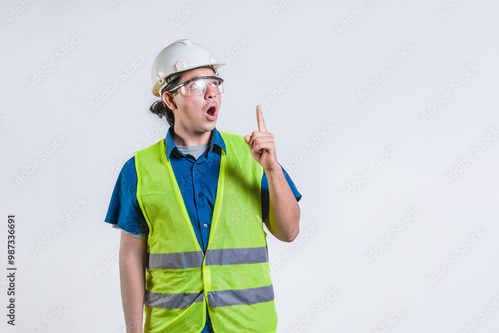 Amazed engineer pointing up isolated. Surprised young architect pointing up. Engineer with astonished face pointing at blank space Amazed engineer pointing up isolated. Surprised young architect pointing up. Engineer with astonished face pointing at blank space
