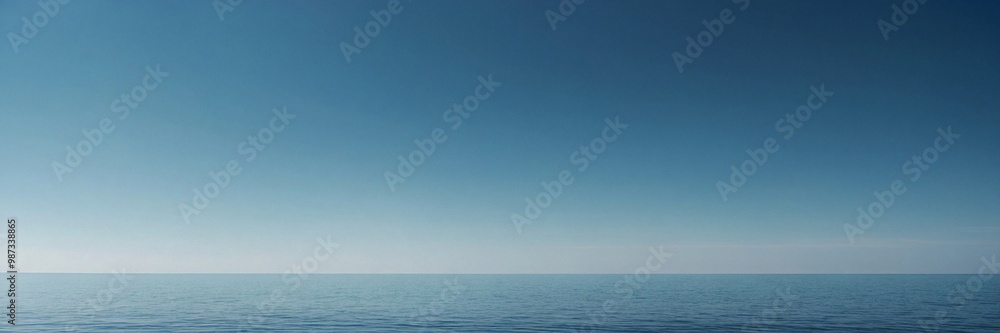 Fototapeta premium A minimalist ocean scene with a seamless gradient sky and faint horizon. The serene blue tones and calm water evoke tranquility and openness, ideal for themes of peace, calm, and vast open spaces.