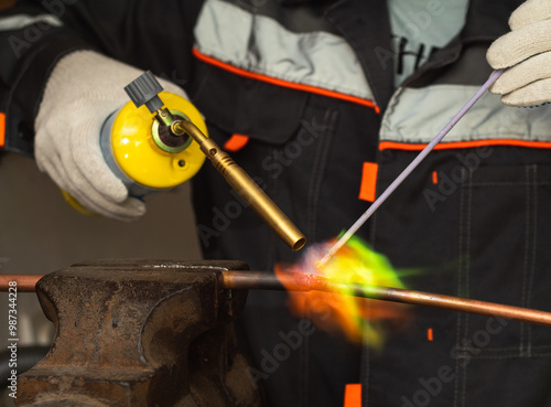 Fotografie soldering copper pipes with a gas torch with mapp gas