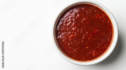 A bowl of brown sauce with a white background.