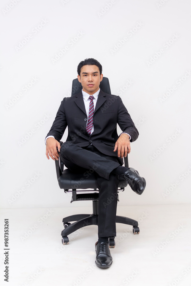 Young Asian businessman seated confidently on a modern office chair Young Asian businessman seated confidently on a modern office chair
