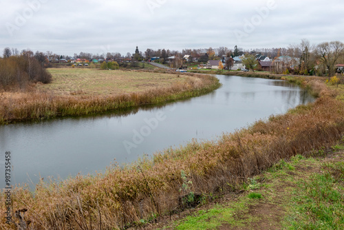 View of the Kamenka River and residential buildings on an autumn day. Suzdal, Vladimir region