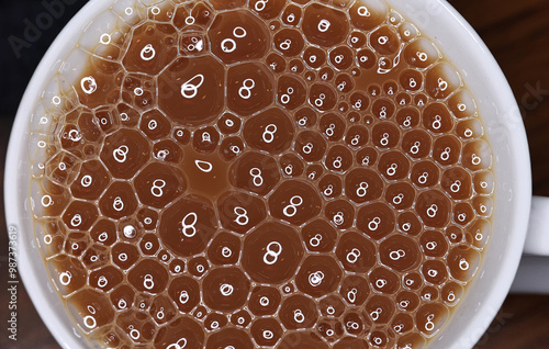 A cup of tea with bubbles and pretty light relections closeup photo