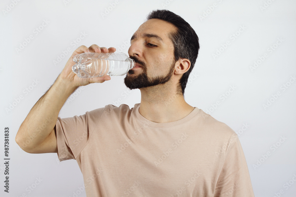 Man drinking water from a bottle on a white background Man drinking water from a bottle on a white background