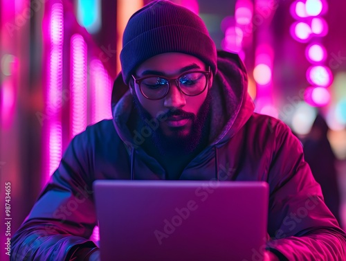 Person working on laptop in neon lights photo