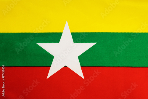 National flag of the state of Myanmar close up. State background.