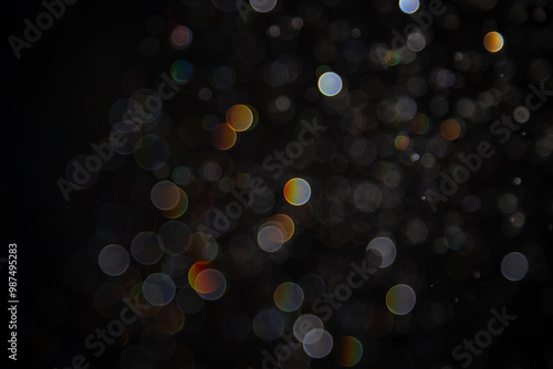 Abstract bokeh lights with colorful circles on dark background, creating a dreamy and festive atmosphere