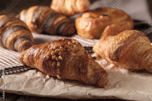 Freshly baked Almond Croissant. Arranged on a cloth and parchment paper.