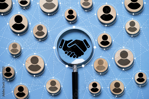 Fotografía Top view design on blue background of Hand shaking inside of magnifier glass which connection with human icon for focus business deal and agreement concept