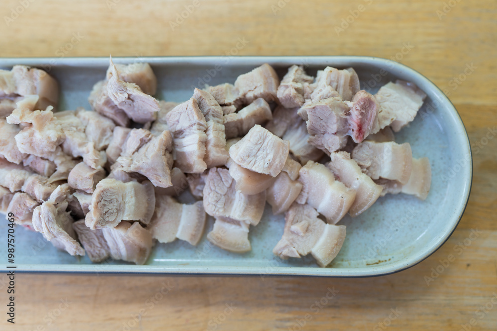 Slices of boiled pork belly bite sized pieces in long tray Slices of boiled pork belly bite sized pieces in long tray