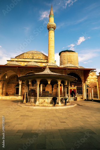 Obraz na płótnie A vibrant view of a historic mosque in Konya, Turkey, showcasing traditional architecture bathed in golden sunlight, with visitors exploring the serene courtyard. Selimiye mosque in konya w salonie