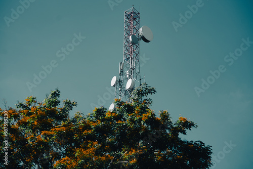 A mobile network tower standing tall against a clear blue sky, essential for telecommunications. photo