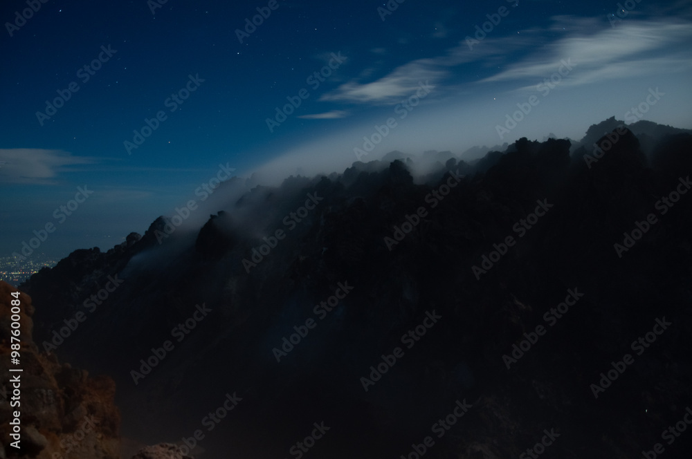 Obraz premium Night view of sulphurous smoke from Merapi Volcano coming out of the rocks in black silhouette