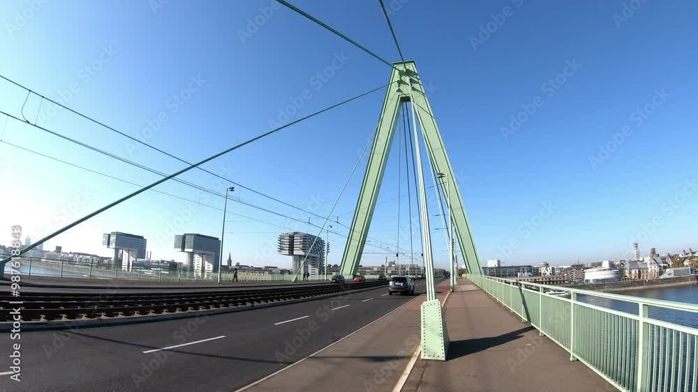 A stunning view of a modern bridge spanning over a tranquil waterway, with city buildings in the background. The clear blue sky adds to the serene atmosphere of this urban landscape. A stunning view of a modern bridge spanning over a tranquil waterway, with city buildings in the background. The clear blue sky adds to the serene atmosphere of this urban landscape.