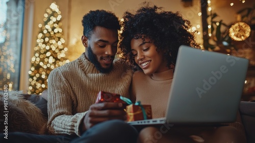 Online shopping at home, a young couple looks for deals and products on their laptop.