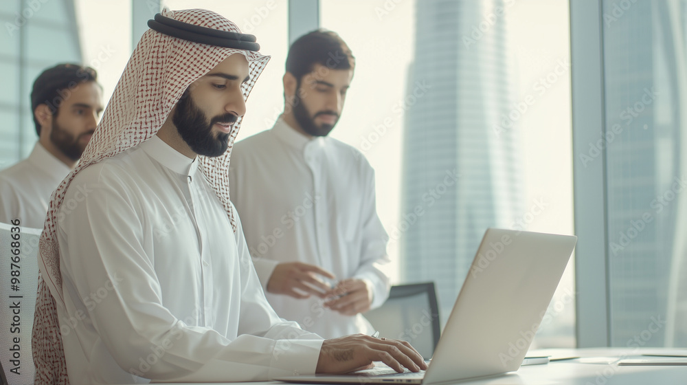 Middle Eastern men and women dressed in traditional Arab clothing stand together at a conference table, collaborating and discussing ideas while using a laptop. photo Middle Eastern men and women dressed in traditional Arab clothing stand together at a conference table, collaborating and discussing ideas while using a laptop. photo