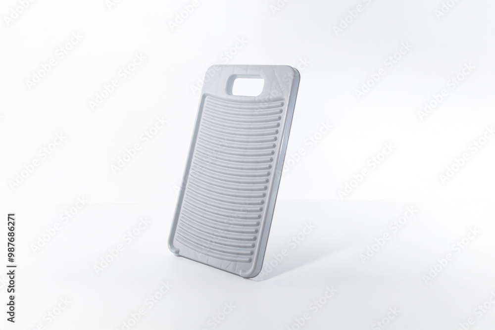 Light gray washboard, plastic material, upright on flat surface, white background, rectangular with rounded corners, vertical ridges, cut-out handle, manual clothes cleaning, functional simplicity, Light gray washboard, plastic material, upright on flat surface, white background, rectangular with rounded corners, vertical ridges, cut-out handle, manual clothes cleaning, functional simplicity,