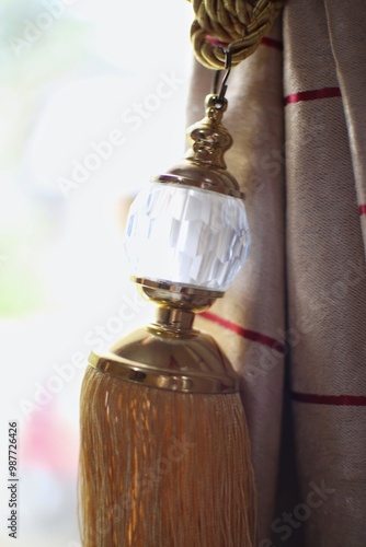 Rokan Hilir, 09-16-2024: Elegant Curtain Tassel Detail in Golden Hues photo