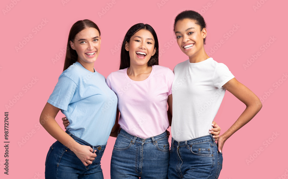 Three Joyful Diverse Women Hugging Standing On Pink Studio Background. Female Friendship. Three Joyful Diverse Women Hugging Standing On Pink Studio Background. Female Friendship.