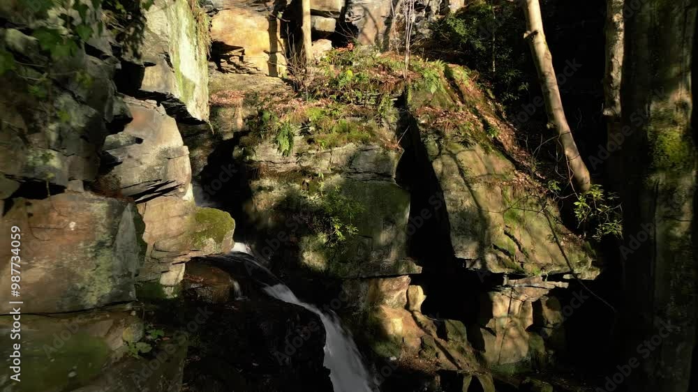 Drone view of Lumsdale waterfall flowing between the rocks in the Peak District in Matlock, England Drone view of Lumsdale waterfall flowing between the rocks in the Peak District in Matlock, England