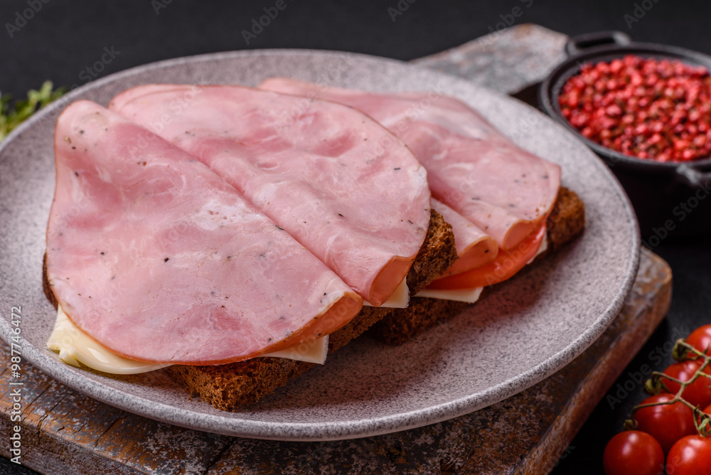 Sandwich with toast, ham, cheese, tomatoes, salt, spices and herbs Sandwich with toast, ham, cheese, tomatoes, salt, spices and herbs