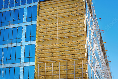 Obraz na płótnie Mineral wool insulation of building facade, thermal insulation of externall wall with wool. Glass wall installation. Installing glazed ventilated facade, building renovation and heat improvement w salonie