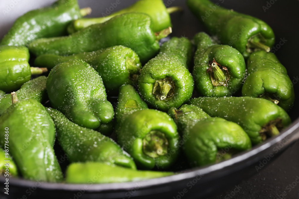 Pimientos de Padron background. Green peppers frying on a black pan. Cooking a Spanish delicacy, sprinkled with salt. Fresh vegetables sizzling in oil, traditional Spanish dish preparation. Pimientos de Padron background. Green peppers frying on a black pan. Cooking a Spanish delicacy, sprinkled with salt. Fresh vegetables sizzling in oil, traditional Spanish dish preparation.