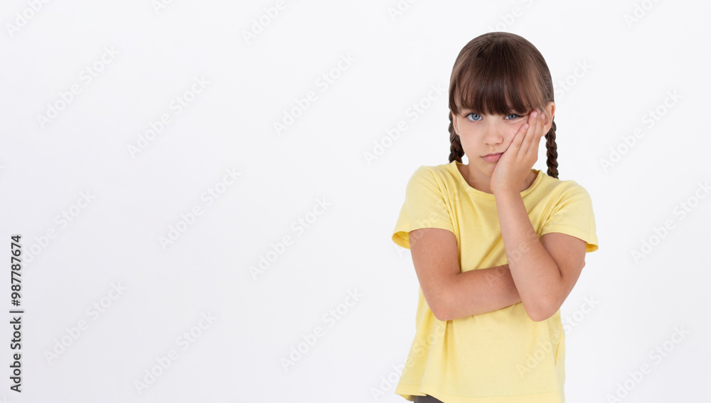 Cute woman standing in yellow t-shirt, holding palm on cheek and leaning face on it, being bored and tired of uninteresting talks, feeling indifferent to what happening over white wall Cute woman standing in yellow t-shirt, holding palm on cheek and leaning face on it, being bored and tired of uninteresting talks, feeling indifferent to what happening over white wall