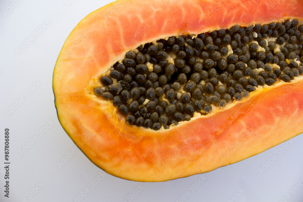 The papaya, with its vibrant orange flesh and round black seeds, is a staple in tropical fruit cuisine, known for its buttery texture and sweet, musky flavor The papaya, with its vibrant orange flesh and round black seeds, is a staple in tropical fruit cuisine, known for its buttery texture and sweet, musky flavor