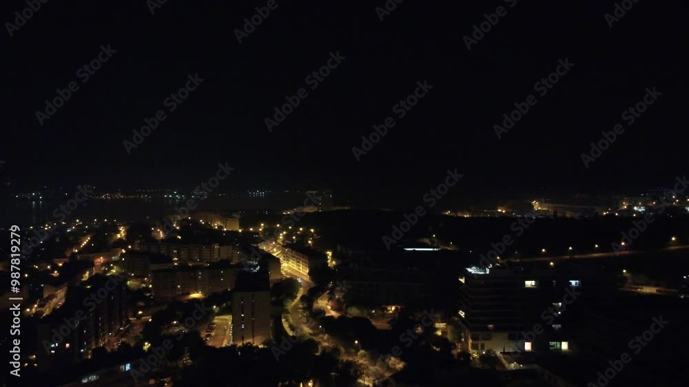Vista aérea noturna da cidade capturada por drone, destacando arranha-céus iluminados e as luzes movimentadas das ruas abaixo Vista aérea noturna da cidade capturada por drone, destacando arranha-céus iluminados e as luzes movimentadas das ruas abaixo