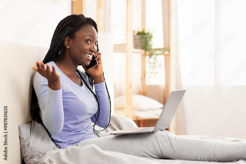 Phone Call. Excited Black Girl Talking On Cellphone Using Laptop Sitting In Bed At Home. Selective Focus, Copy Space Phone Call. Excited Black Girl Talking On Cellphone Using Laptop Sitting In Bed At Home. Selective Focus, Copy Space