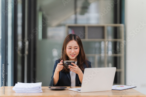 Focused Asian Businesswoman Enjoys Coffee Break
