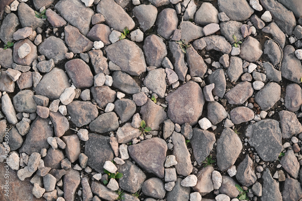 Top view of stone road fragment. Dry land with stones. Abstract natural textured background. Top view of stone road fragment. Dry land with stones. Abstract natural textured background.