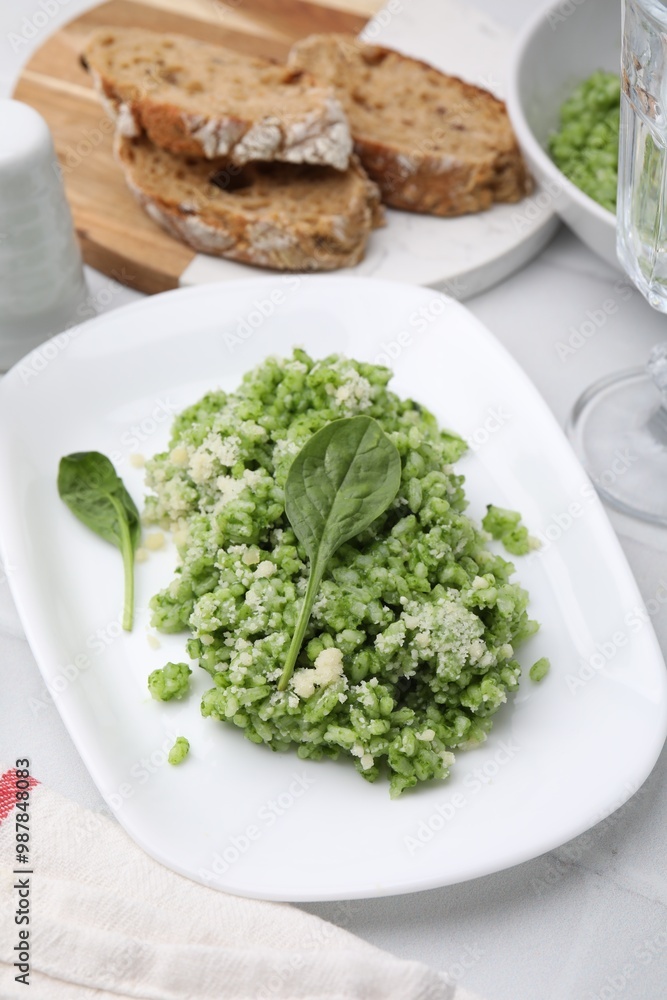 Delicious spinach risotto with parmesan cheese on white tiled table Delicious spinach risotto with parmesan cheese on white tiled table