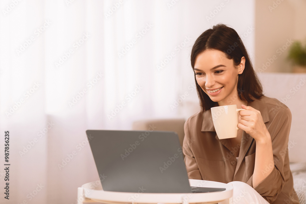 Surfing Internet. Happy Girl Relaxing With Cup Of Hot Coffee, Using Laptop, Spending Time At Home, Free Space Surfing Internet. Happy Girl Relaxing With Cup Of Hot Coffee, Using Laptop, Spending Time At Home, Free Space