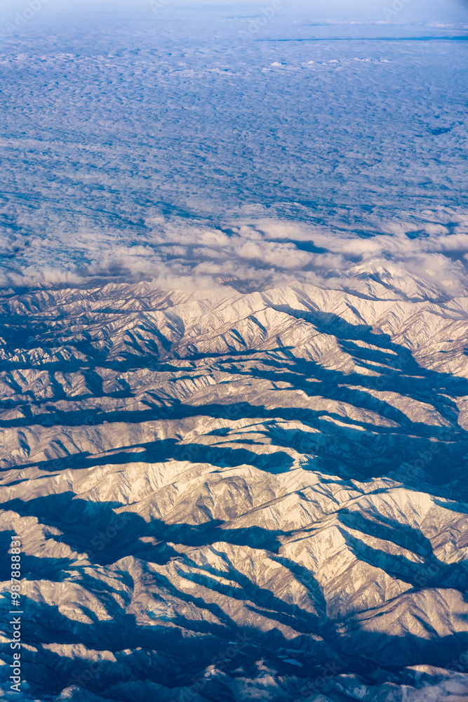 Fototapeta premium Airplane cabin view of snow covered mountains in Northern Honshu, Japan