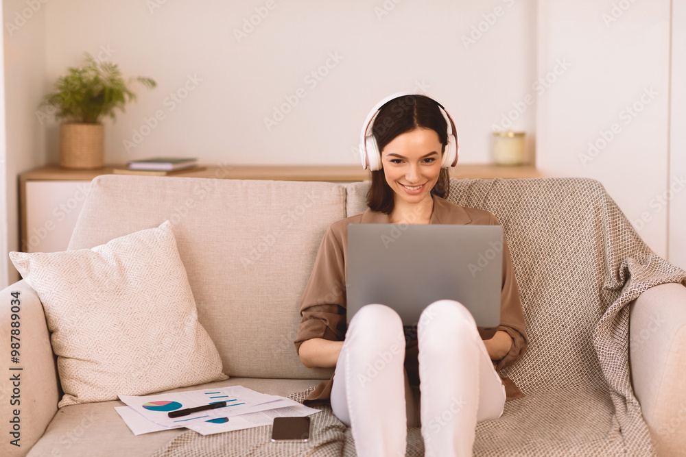Favourite Song. Cheerful freelancer working on laptop sitting on couch and listening to music in headphones, copyspace Favourite Song. Cheerful freelancer working on laptop sitting on couch and listening to music in headphones, copyspace