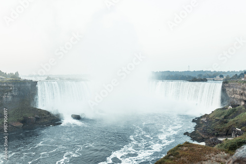 Niagara Falls presents a breathtaking view with its powerful, cascading water plunging into the misty gorge below.