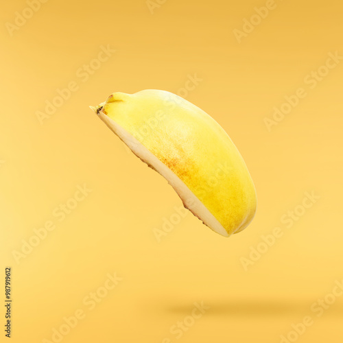 Fresh ripe yellow Quince fruit  falling in the air isolated on yellow background. Food levitation or zero gravity conception