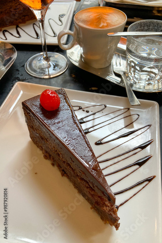 Slice of Sacher Torte cake on plate at Cafe in Vienna, Austria. Famous Austrian chocolate sponge cake with apricot jam close-up photo