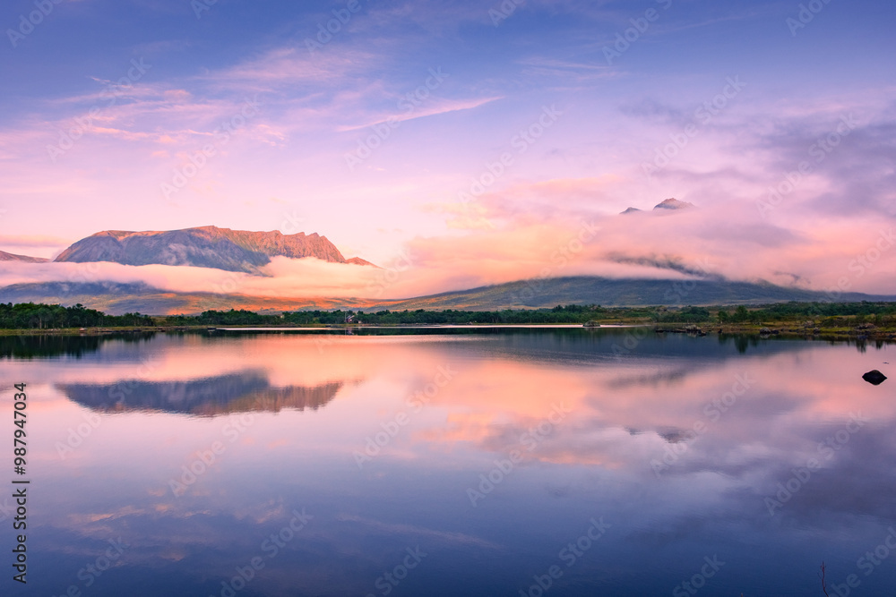 Spectacular reflection of the mountains on a lake with mist under the midnight sun, fairy tale atmosphere in the Vesteralen Islands, Norway Spectacular reflection of the mountains on a lake with mist under the midnight sun, fairy tale atmosphere in the Vesteralen Islands, Norway