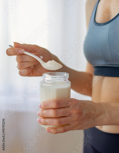 Young sporty woman pouring protein powder into a cup to make replacement food meal after workout
 photo