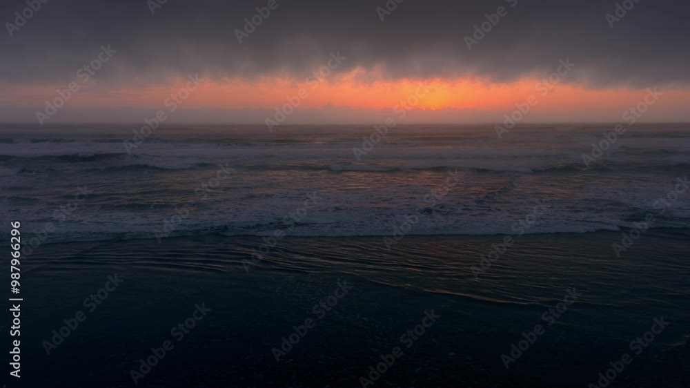 Wild ocean surf beach during a foggy sunset. Piha, Auckland, New Zealand. Wild ocean surf beach during a foggy sunset. Piha, Auckland, New Zealand.