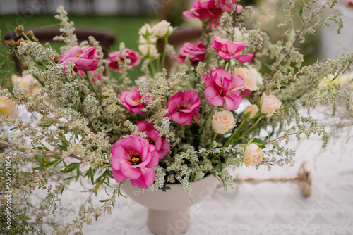 Elegant flower arrangement with pink and peach flowers in a white vase.