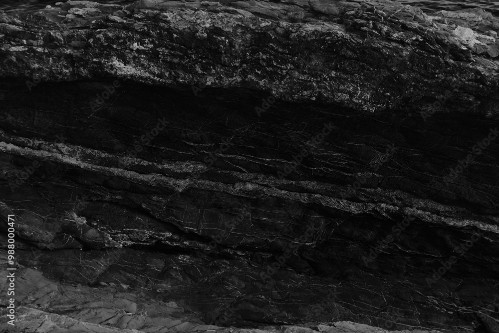 Black and white beach with a huge rock and sea waves. Rock and stone texture Black and white beach with a huge rock and sea waves. Rock and stone texture