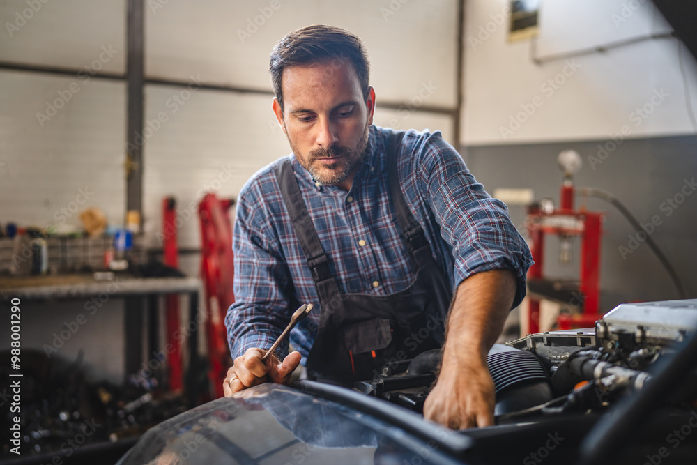 Focused car mechanic work on car engine in automotive workshop Focused car mechanic work on car engine in automotive workshop