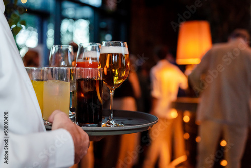 Waiter holding tray with beers and sodas at an elegant event