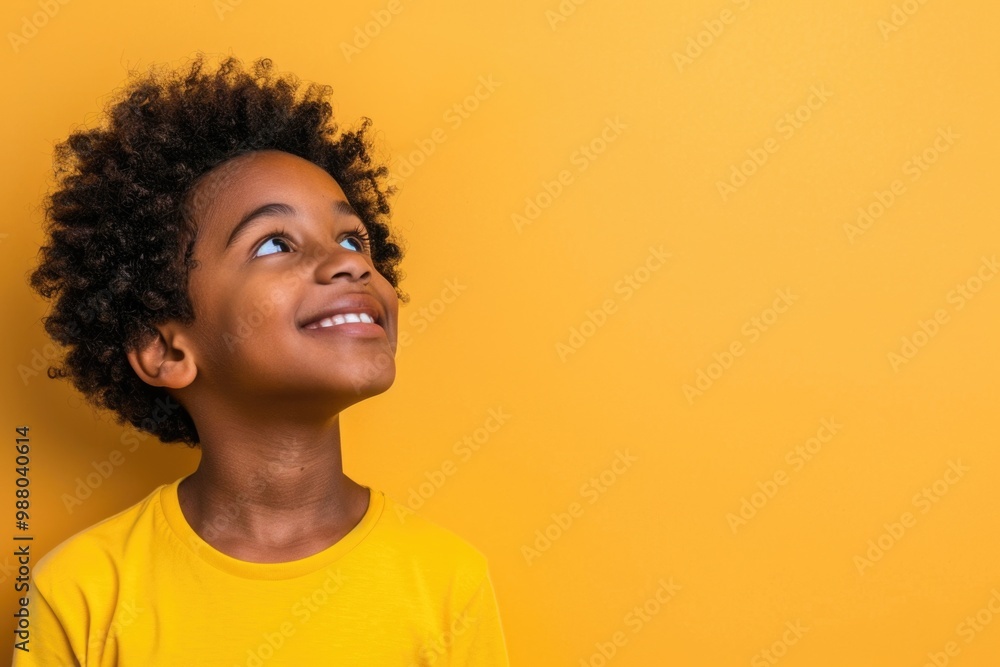Joyful young boy against yellow background looking upward. AI Joyful young boy against yellow background looking upward. AI