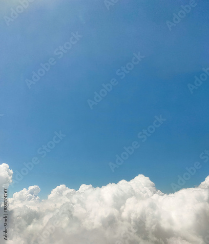 Close up photo of fluffy white cumulus clouds in a blue sky with copy space image